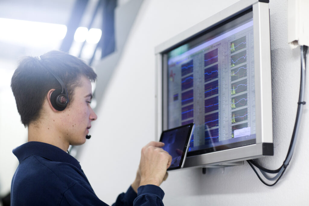 Low angle side view of young man wearing headset using digital tablet